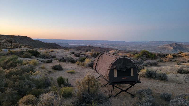 Sunrise over canyon plateau with tent cot