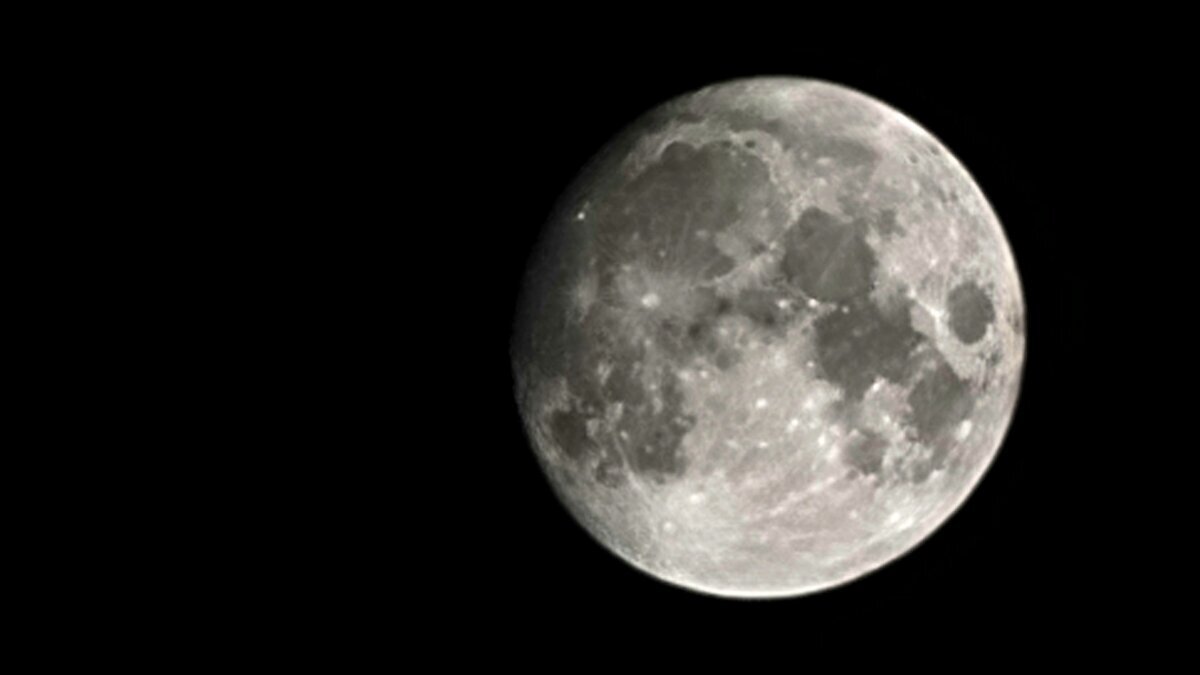 Full moon over a black desert night sky